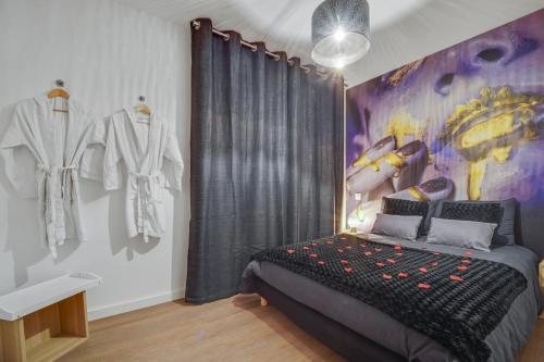 una camera da letto con un letto e un quadro sul muro di SWEET ANGEL Suite romantique avec SPA a Bruz