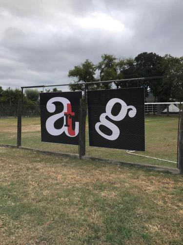 two signs on a fence in a field at Apart Gallery - San Lorenzo - Salta in Salta