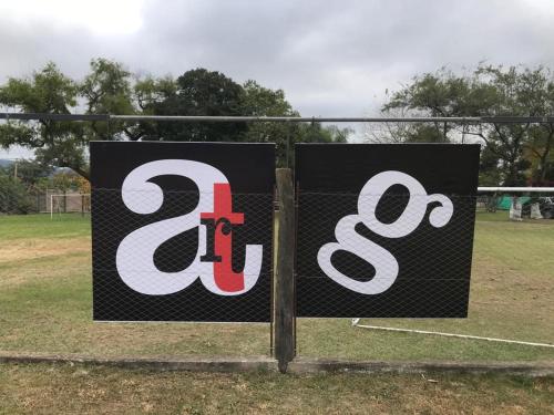 a sign on a fence in a soccer field at Apart Gallery - San Lorenzo - Salta in Salta