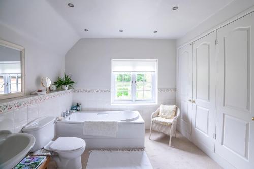 uma casa de banho branca com uma banheira, um WC e um lavatório. em Pelham Grove em Shrewsbury