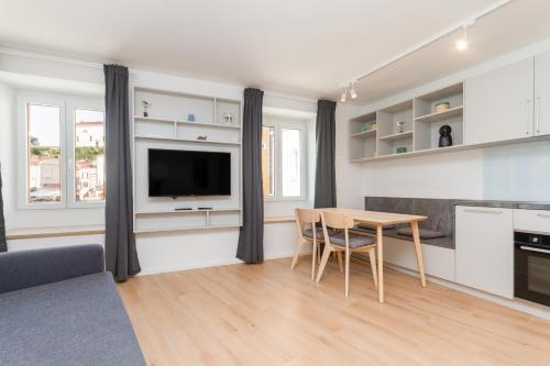 a kitchen and dining room with a table and a tv at Premium Tartini Apartment 2 by Locap Group in Piran