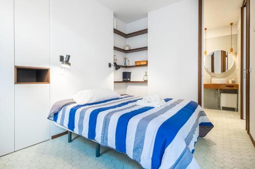 ein Schlafzimmer mit einem Bett mit einer blau-weißen gestreiften Decke in der Unterkunft San Vicente 31 Old Town in Benidorm
