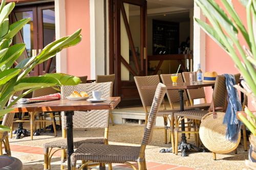 an outdoor patio with wooden tables and chairs at Hôtel Du Golfe in Ajaccio
