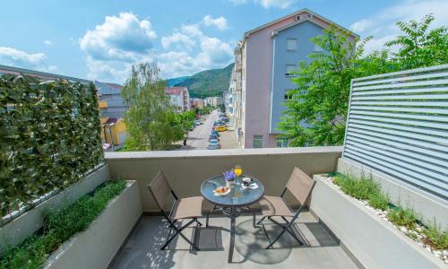 eine Terrasse mit einem Tisch und Stühlen auf dem Balkon in der Unterkunft Apartment Sun in Mostar