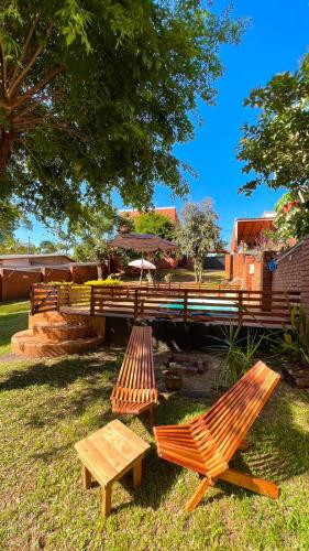 two wooden benches and a picnic table in the grass at Hiraya Apart in Puerto Iguazú
