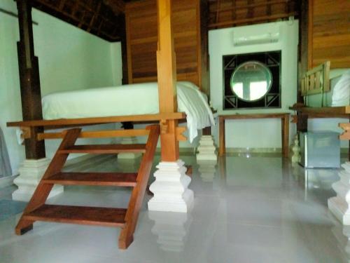 a bedroom with a bed and a ladder and a mirror at Pier26 Bali Homestay in Nusa Dua