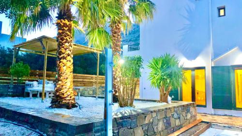 a group of palm trees in front of a building at Haroupia The Residence in Kalidhón