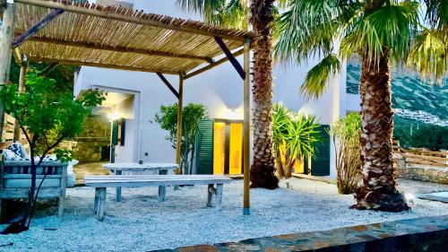 a picnic table on the beach with palm trees at Haroupia The Residence in Kalidhón