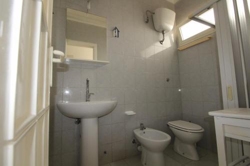 bagno bianco con lavandino e servizi igienici di appartamento Perla marina gallipoli a Lido Conchiglia