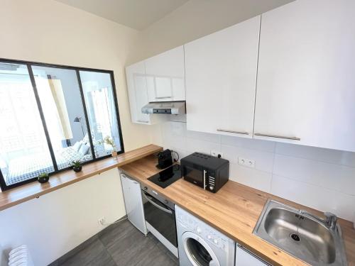 une cuisine avec un évier et un micro-ondes dans l'établissement Nice Renting - BUFFA - Cosy Studio fully equipped - Beach & Negresco, à Nice