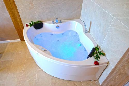 a bath tub in a bathroom with a blue bath tub at Paradise Hotel & Relax Center in Pomorie