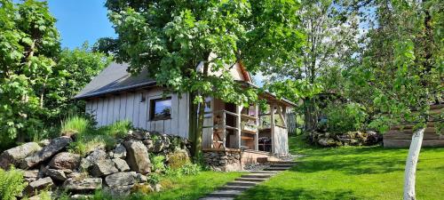 a small house in a yard with a stone wall at Lavendowo in Piechowice