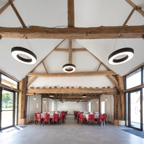 Cette grande chambre comprend des chaises et des tables rouges. dans l'établissement Gite de la Gandonnière - Au pied du circuit des 24hr, pour 10 à 31 personnes, à Teloché