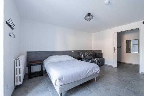 a bedroom with a bed and a couch at Gite de la Gandonnière - Au pied du circuit des 24hr, pour 10 à 31 personnes in Teloché