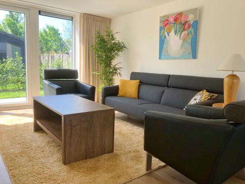 a living room with a couch and a coffee table at Bungalow 74 op Recreatiepark De Wielen in Sint Maarten