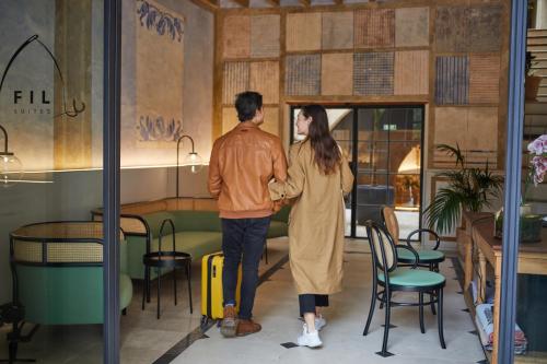 a man and a woman walking through a restaurant at Fil Suites in Palma de Mallorca