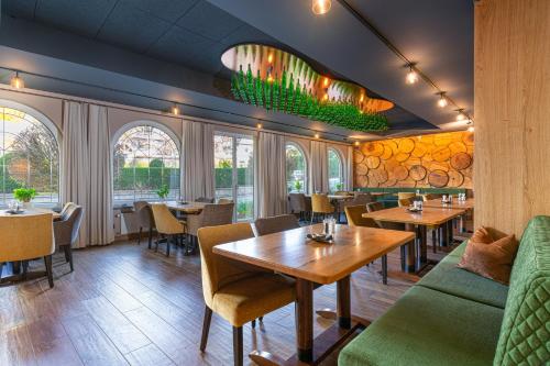 een restaurant met tafels, stoelen en ramen bij Hotel Restaurant Pollmanns in Ernst