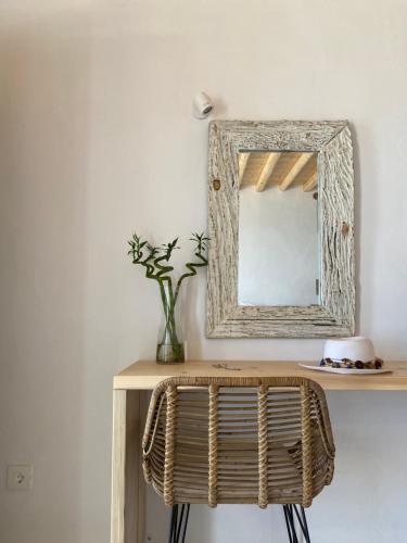 a mirror on a wall next to a vase of flowers at Gerofinikas Boutique Hotel in Apollonia