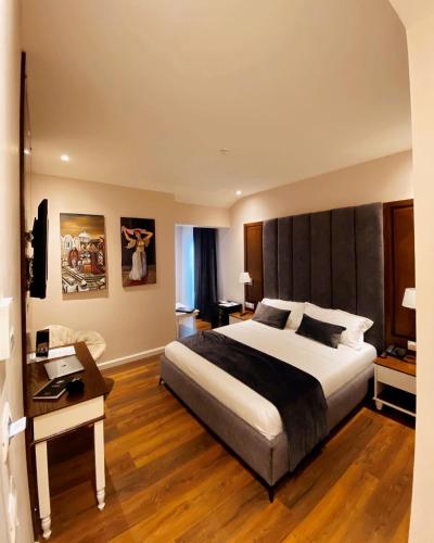 a bedroom with a large bed and a desk at Arberia Palace Hotel in Fushë-Milot
