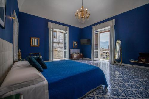 ein blaues Schlafzimmer mit einem Bett mit blauen Wänden in der Unterkunft Crudo Home in Pompei