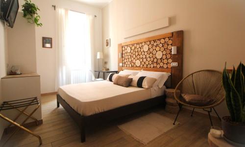a bedroom with a bed with a wooden headboard and a chair at Adventor Eco-Suites in Rome