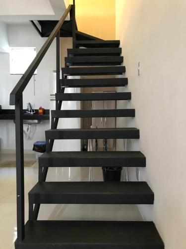 a staircase with black risers in a room at Suíte no Mirante em Escarpas in Capitólio