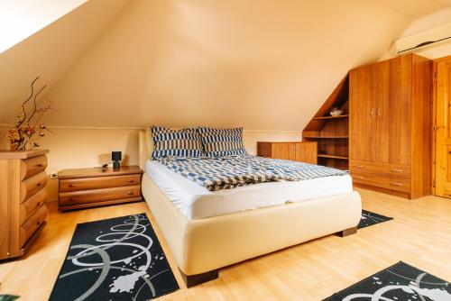 a bedroom with a bed and a book shelf at Buzavirág Apartman in Keszthely