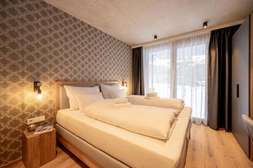 a bedroom with a large bed and a large window at GRIMMINGlofts Top 7 in Bad Mitterndorf
