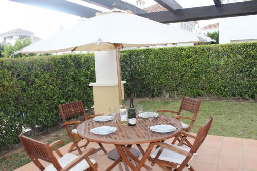 una mesa y sillas con una sombrilla en el patio en Villa en La Torre Golf Resort by Rental Olé, en Torre-Pacheco