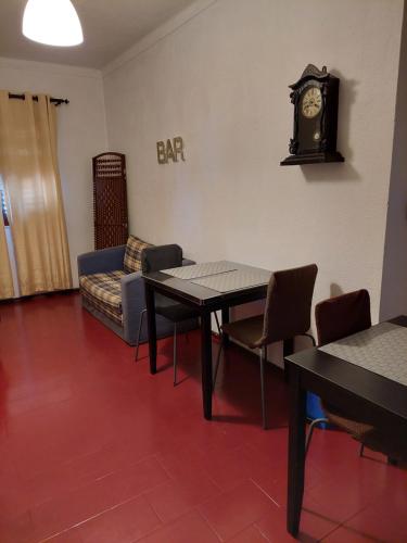 a waiting room with a table and a clock on the wall at Quartos da Vóvó in Avis