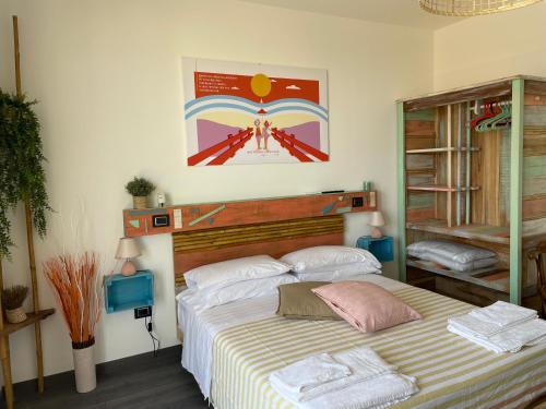 a bedroom with a large bed with a striped blanket at Homiday - Bel Salento Specchia in Specchia