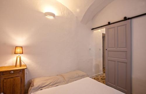 um quarto com uma cama, um candeeiro e uma porta em Casa Rione em Omessa