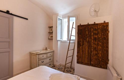 um quarto com uma escada ao lado de uma cómoda e uma janela em Casa Rione em Omessa