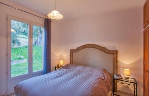 een slaapkamer met een bed en een groot raam bij Domaine Bollaccia - Casa Bodri in Monticello