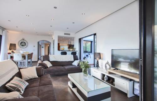 sala de estar con sofá y TV de pantalla plana en Villa Annonciade en LʼÎle-Rousse