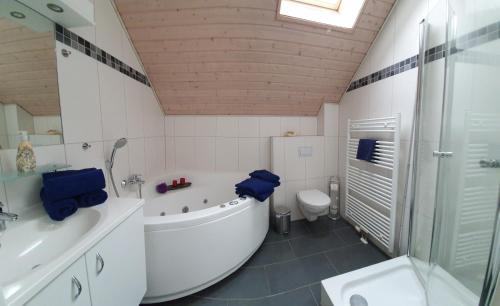 ein Badezimmer mit einer Badewanne, einem WC und einem Waschbecken in der Unterkunft Sonnendeck in Greetsiel