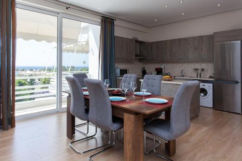 a kitchen and dining room with a wooden table and chairs at Artistic 3 bedroom apartment with sea view in Glyfada in Athens
