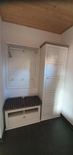 a white closet with a bench in a room at Sandburg in Greetsiel