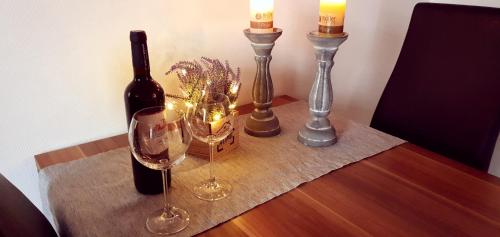 a table with a bottle of wine and two glasses at Sandburg in Greetsiel