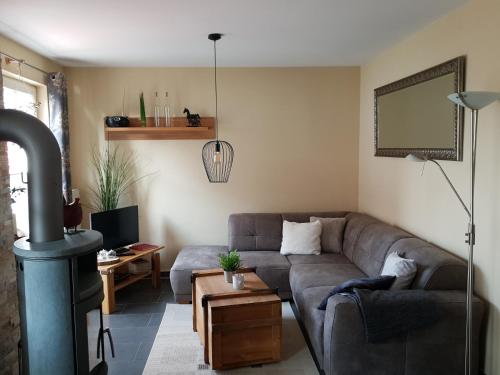 uma sala de estar com um sofá e um fogão a lenha em Dat Diekhus em Greetsiel