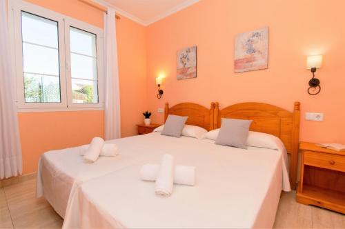 twee bedden in een kamer met twee ramen bij Villa Miel by Sonne Villas in Cala Galdana