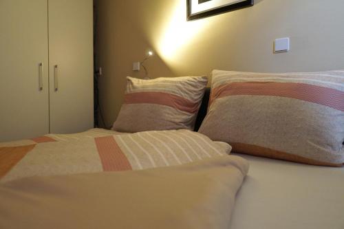 a bedroom with a bed with two pillows on it at Dat Diekhus in Greetsiel