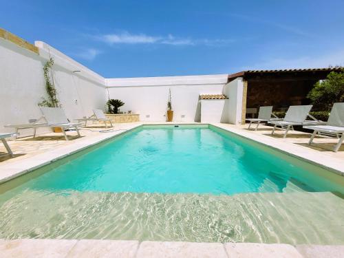 een zwembad met blauw water in een huis bij Villa Cigaline in Tiggiano