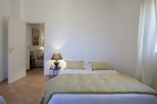 Santa-Reparata-di-BalagnaにあるCasa Gentileのベッドルーム1室(ベッド1台、ランプ付きテーブル付)