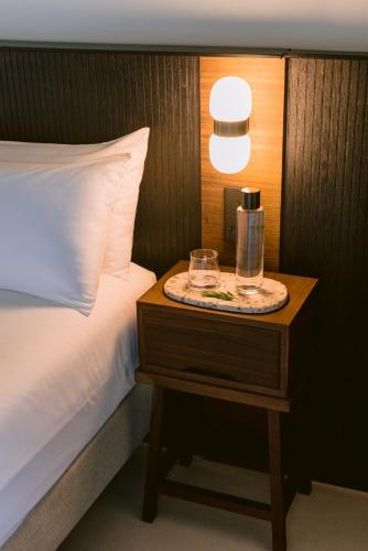 a bed with a nightstand with a bottle on it at Casa Maca in Ibiza Town