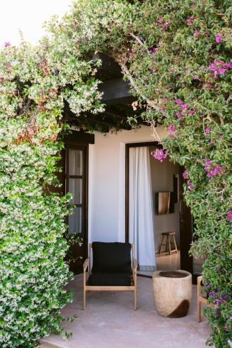 a chair sitting on a patio with flowers at Casa Maca in Ibiza Town