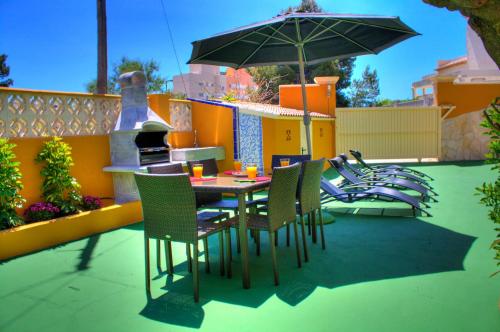 einen Tisch und Stühle mit Sonnenschirm auf einer Terrasse in der Unterkunft Villa Benicuco 4 - PlusHolidays in Calpe