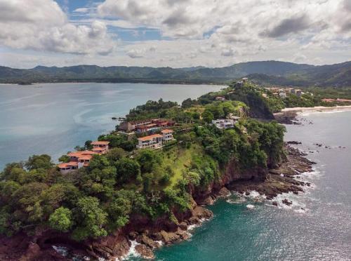 an island in the water with houses on it at Playa Flamingo penthouse with pacific sunset views - Flamingo Rose Vista in Playa Flamingo