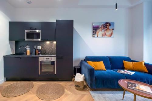 un salon avec un canapé bleu et une cuisine dans l'établissement Superbe 2P Plage/ Promenade des Anglais 201, à Nice