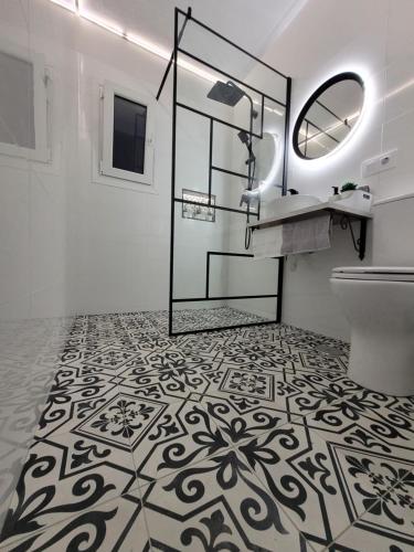 La salle de bains est pourvue de toilettes, d'un lavabo et d'un miroir. dans l'établissement Apartamento ClaVer, à Vejer de la Frontera
